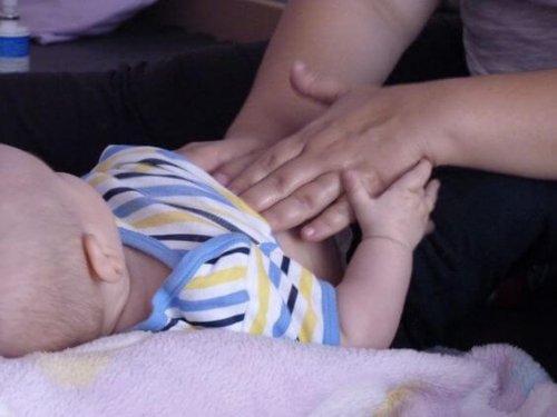 bebeğine karın masajı yapan anne