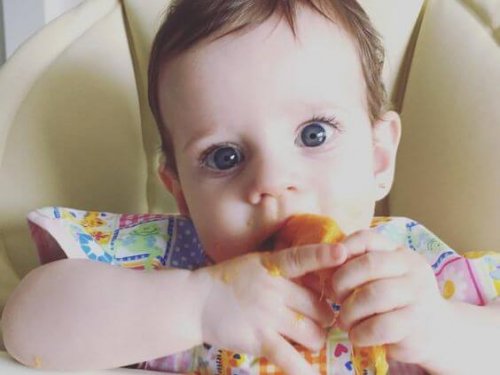 eliyle yemek yiyen bebek