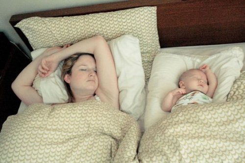 yatakta uyuyan anne ve bebek
