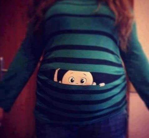 annesinin karnından bakan bebek karikatürü