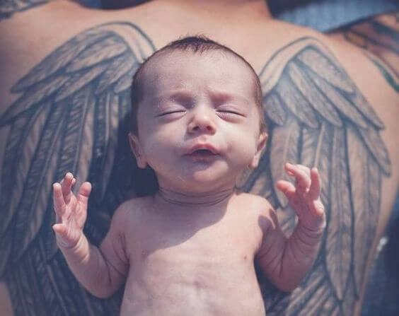 babasının sırtında yeni doğan bebek