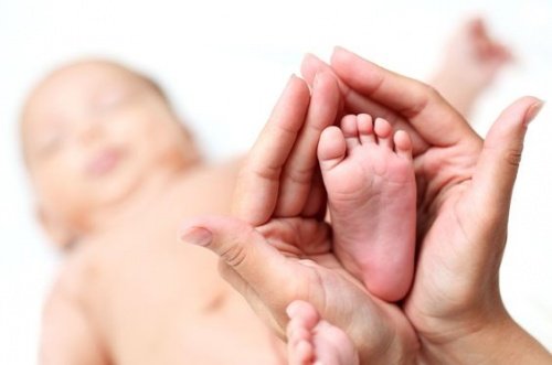 bebeğinin ayağını tutan anne eli