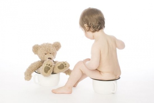 oyuncak ayısıyla lazımlıkta oturan bebek