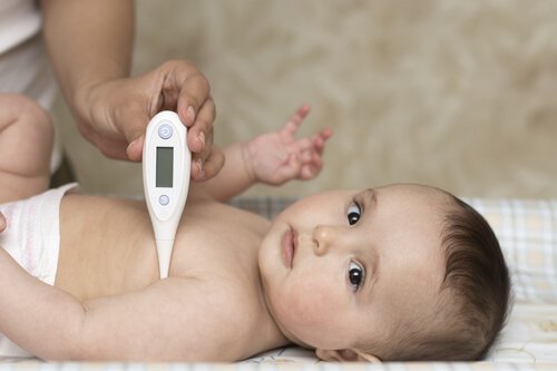 dereceyle ateşi ölçülen bebek