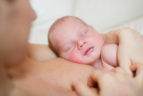 yeni doğan bebeği göğsünde uyutan anne