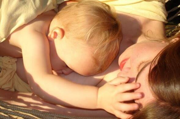güneşte yatan anne ve bebek