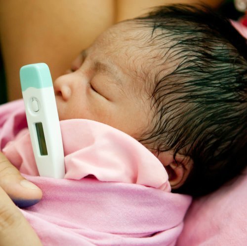 dereceyle ateşi ölçülen bebek