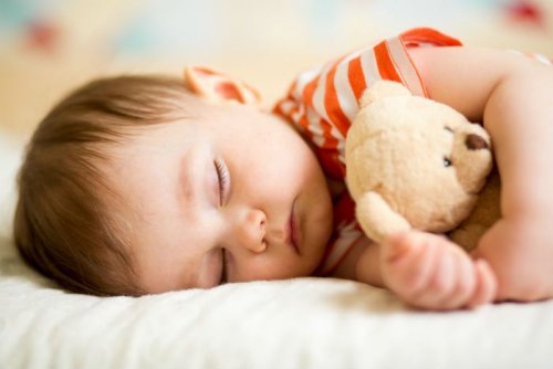 oyuncak ayısıyla uyuyan çocuk