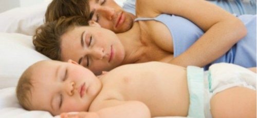 bebekleriyle beraber uyuyan aile