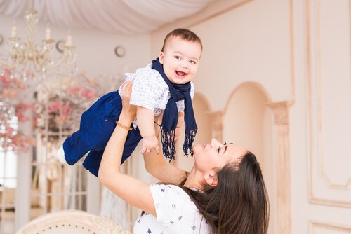 bebeğini havaya kaldıran anne