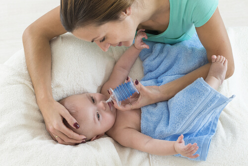bebeğinin burnunu temizleyen anne