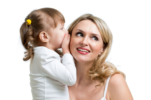 annesinin kulağına fısıldayan kız çocuk