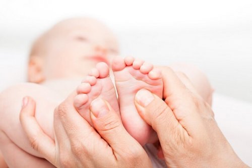 ayağına masaj yapılan bebek