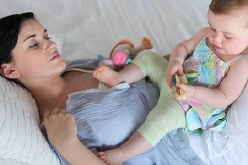 kucağında bebeğiyle yatakta anne