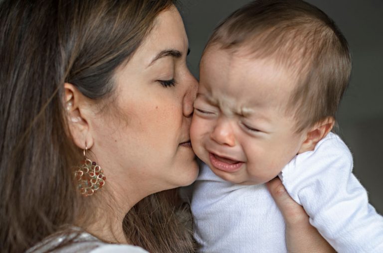 ağlayan bebeğini öpen anne