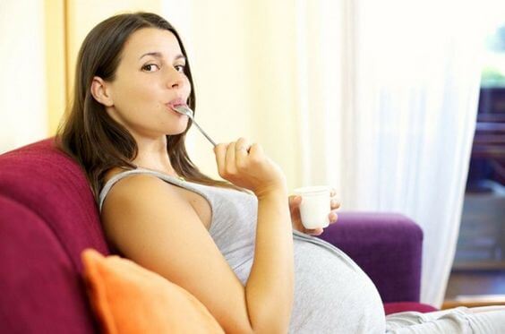 kaşıkla yemek yiyen hamile kadın