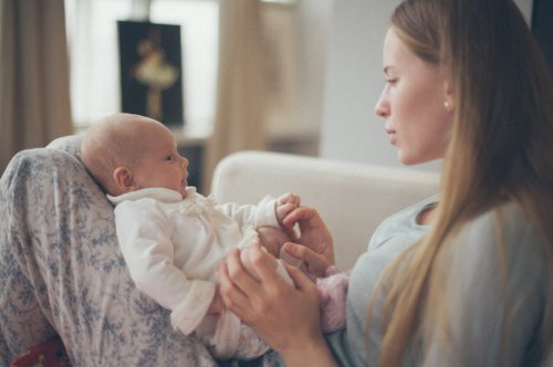 kucağında yenidoğanıyla oynayan anne