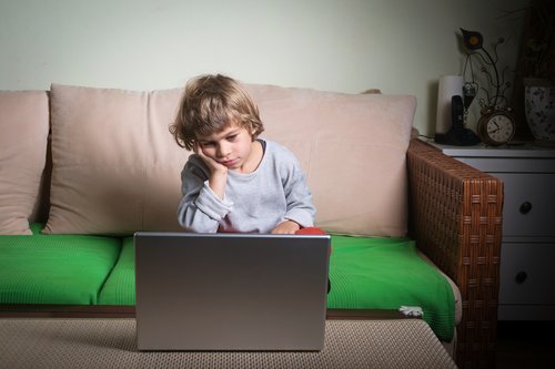 bilgisayarda sıkılan çocuk