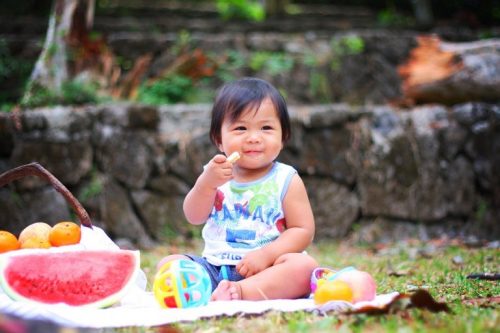 bahçede meyve yiyen çocuk