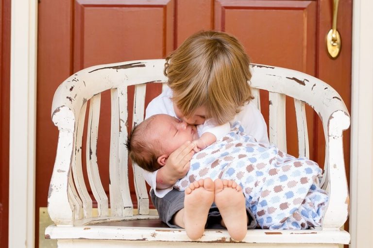 yenidoğan kardeşini öpen çocuk