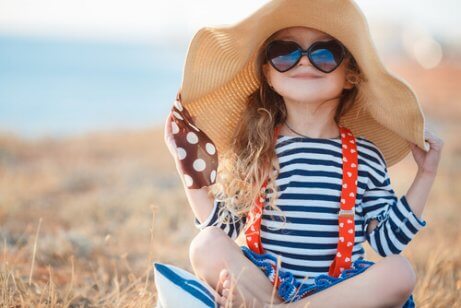 sahilde şapkalı ve gözlüklü çocuk