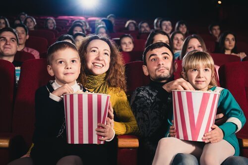 sinemada oturan film izleyen aile