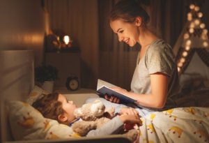 Yatmadan önce çocuğuna hikayeler okuyan anne