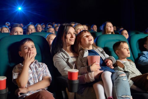 Sinema salonunda çocuk filmleri izleyen anne ve çocuklar