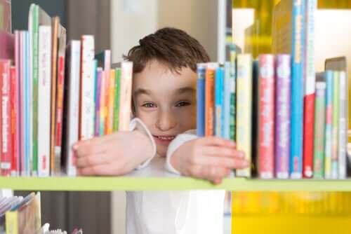 Kütüphanede kitaplar arasından gülümseyen çocuk