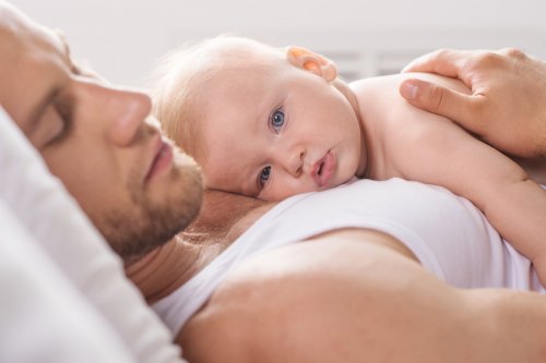 Babasının göğsünde yatan ve etrafı seyreden bebek