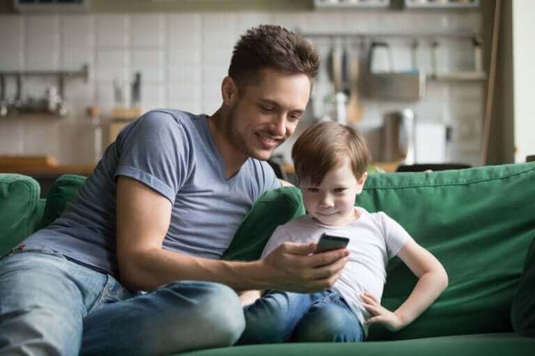 Çocuğuna telefonunu gösteren baba
