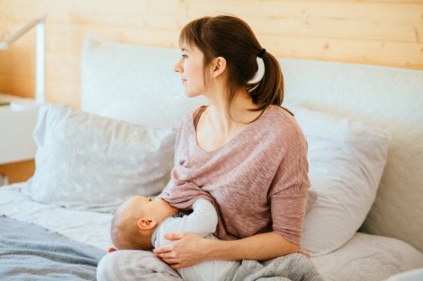 Yatakta bebeğini emziren anne