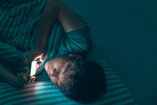 Gece cep telefonu ile ilgilenen genç