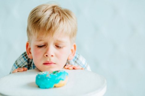 Gluten intoleransı yüzünden üzülerek keke bakan çocuk