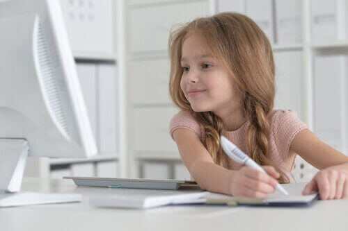 Bilgisayara bakarak ödev yapan kız