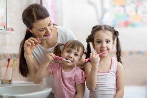 dişlerini fırçalayan anne ve çocuklar