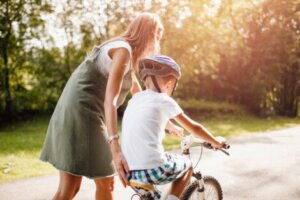 Anne oğluna bisiklete binmeyi öğretiyor