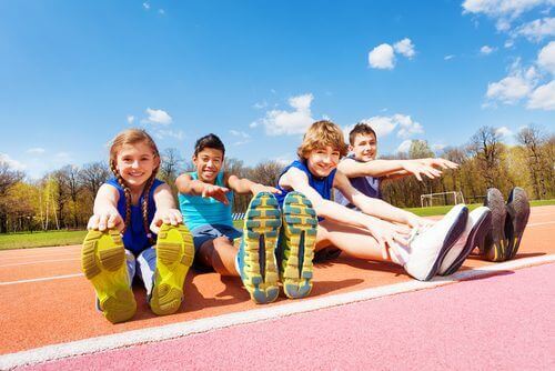 Spor sahasında esneme yapan çocuklar