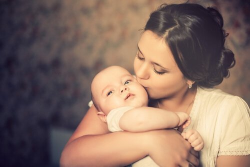 Annelik içgüdüsü ile çocuğunu öpen anne