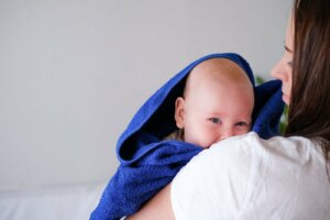 banyo havlusuna sarılı bir bebek ve annesi