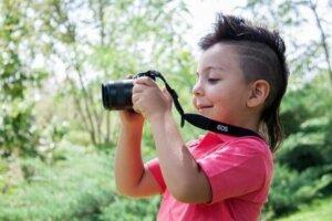 Ormanda kamerasıyla çekim yapan bir çocuk