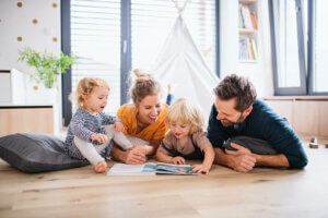 Yerde birlikte kitap okuyan bir aile