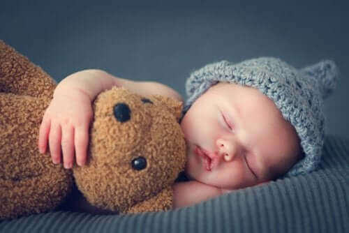 bebekler ilk üç aylık süreçte nasıl uyur: oyuncak ayıya sarılarak uyuyan bebek