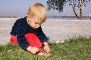 Küçük bir çocuk ayakkabı bağcığını bağlıyor
