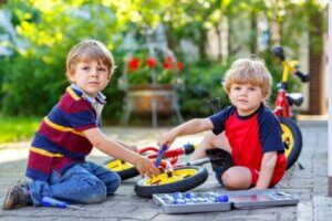 İki çocuk oyuncak bisikletlerini tamir etmeye çalışıyor