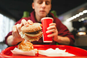 hamburger menü yiyen genç 