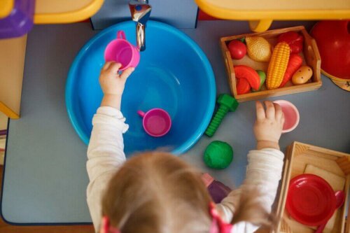 Oyuncak mutfak eşyalarını düzenleyen bir çocuk.