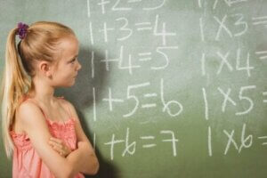 küçük kız çocuğu tahtada yapılan matematik işlemlerine bakıyor