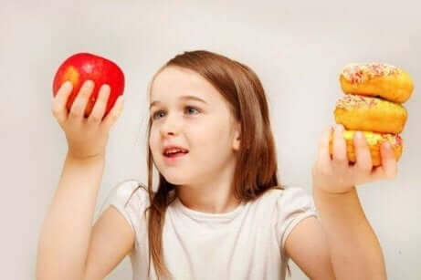 Elinde elma ve kek tutan kız