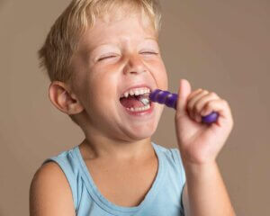 gülerek diş fırçalayan bir çocuk